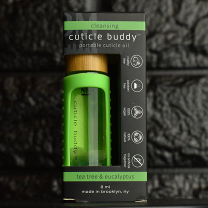 cuticle buddy™ cleansing portable cuticle oil inside it's packaging box next to black brick