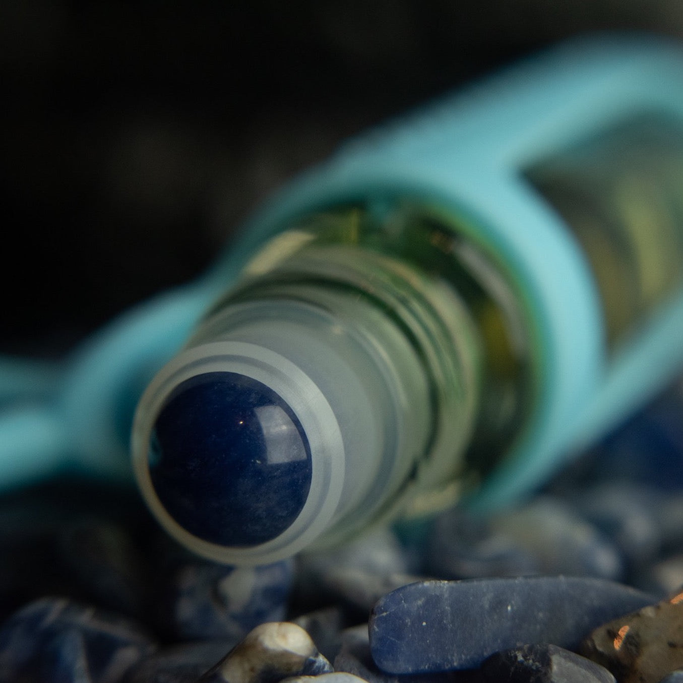 blue sodalite rollerball closeup in a pile of blue sodalite stones