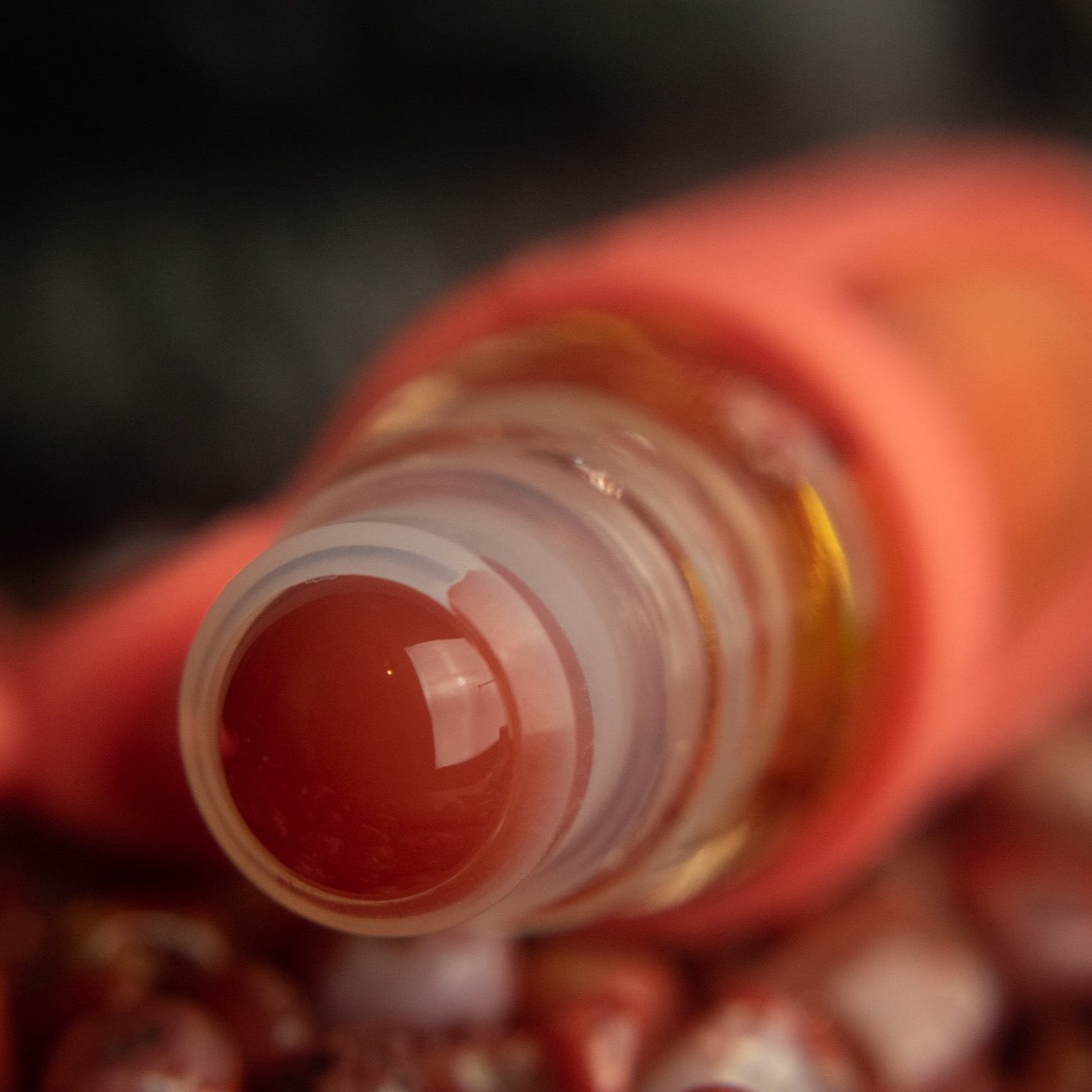 red agate rollerball closeup in a pile of red agate stones
