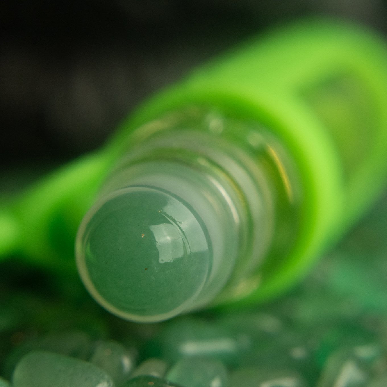 green aventurine rollerball closeup in a pile of green aventurine stones