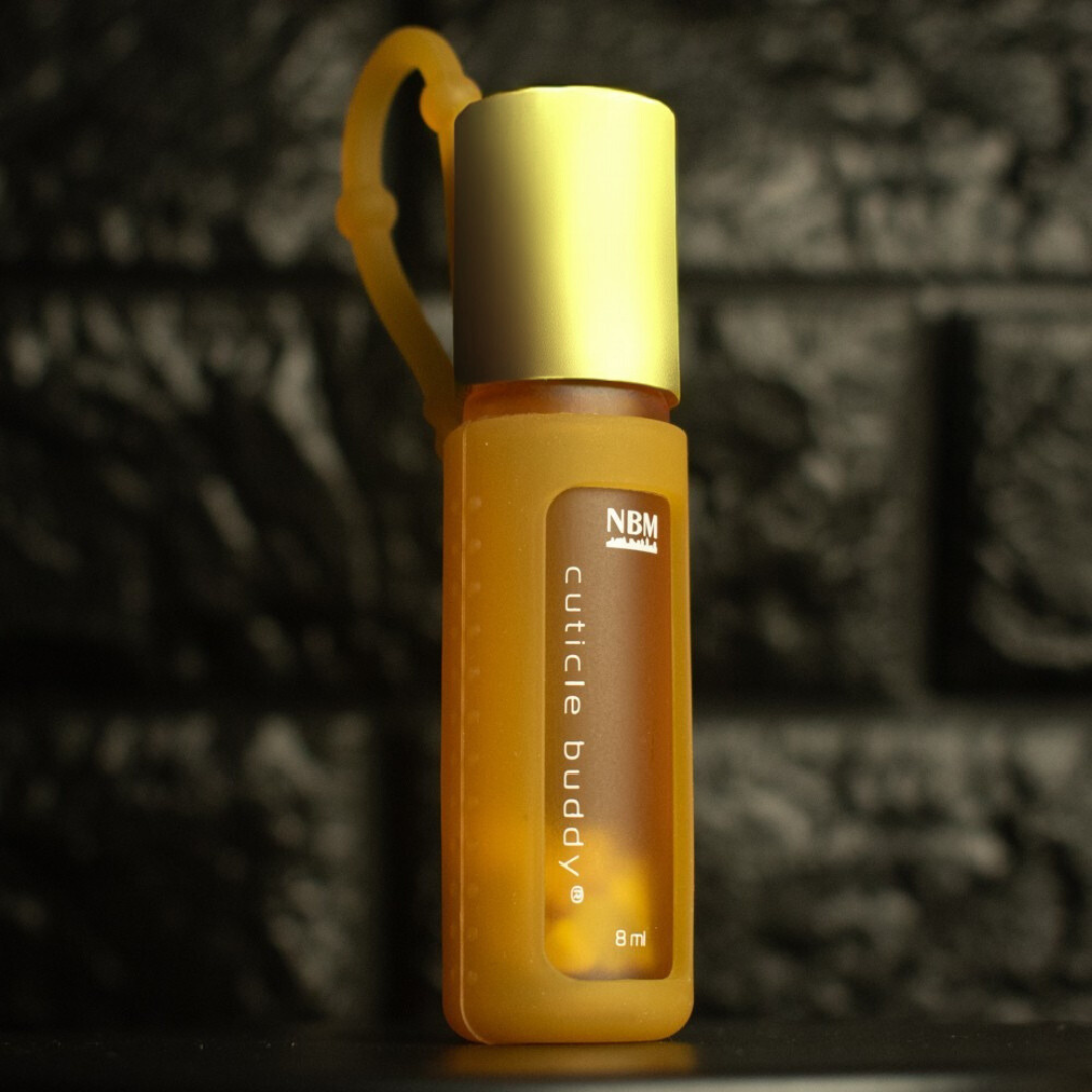 yellow frosted bottle labeled cuticle buddy 8ml  in a yellow silicone holder with a gold aluminum cap