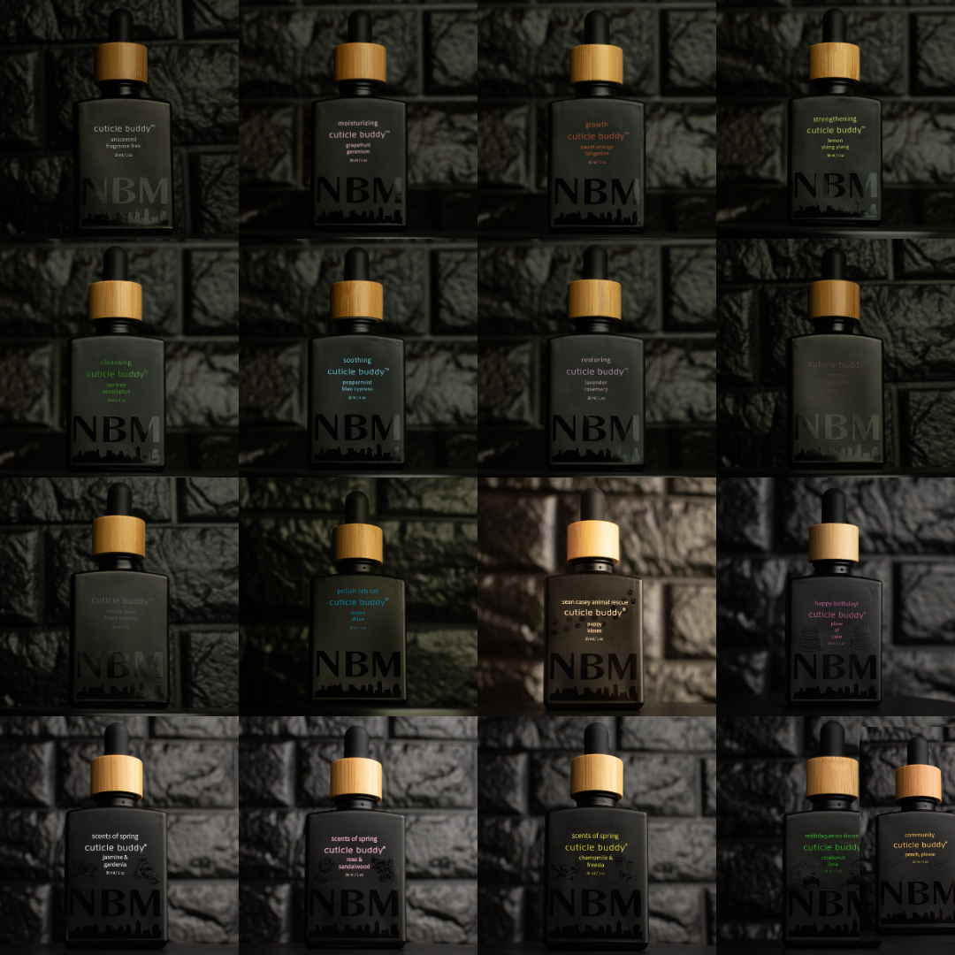Multiple bottles of NBM dropper bottle cuticle oil cuticle buddy refills arranged in a grid on a textured dark background