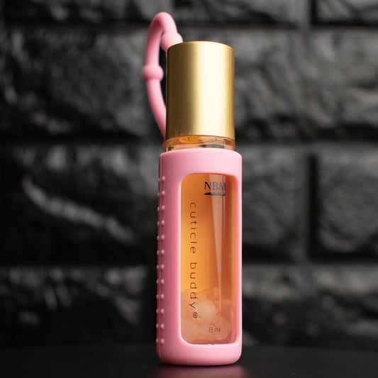 bottle of cuticle oil with gold cap in a pink silicone holder