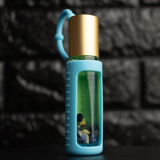bottle of cuticle oil with gold cap in a blue silicone holder