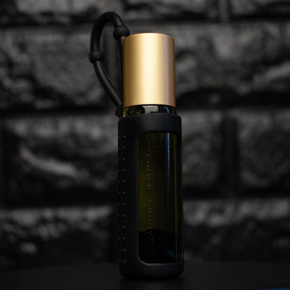 bottle of cuticle oil with gold cap in a black silicone holder