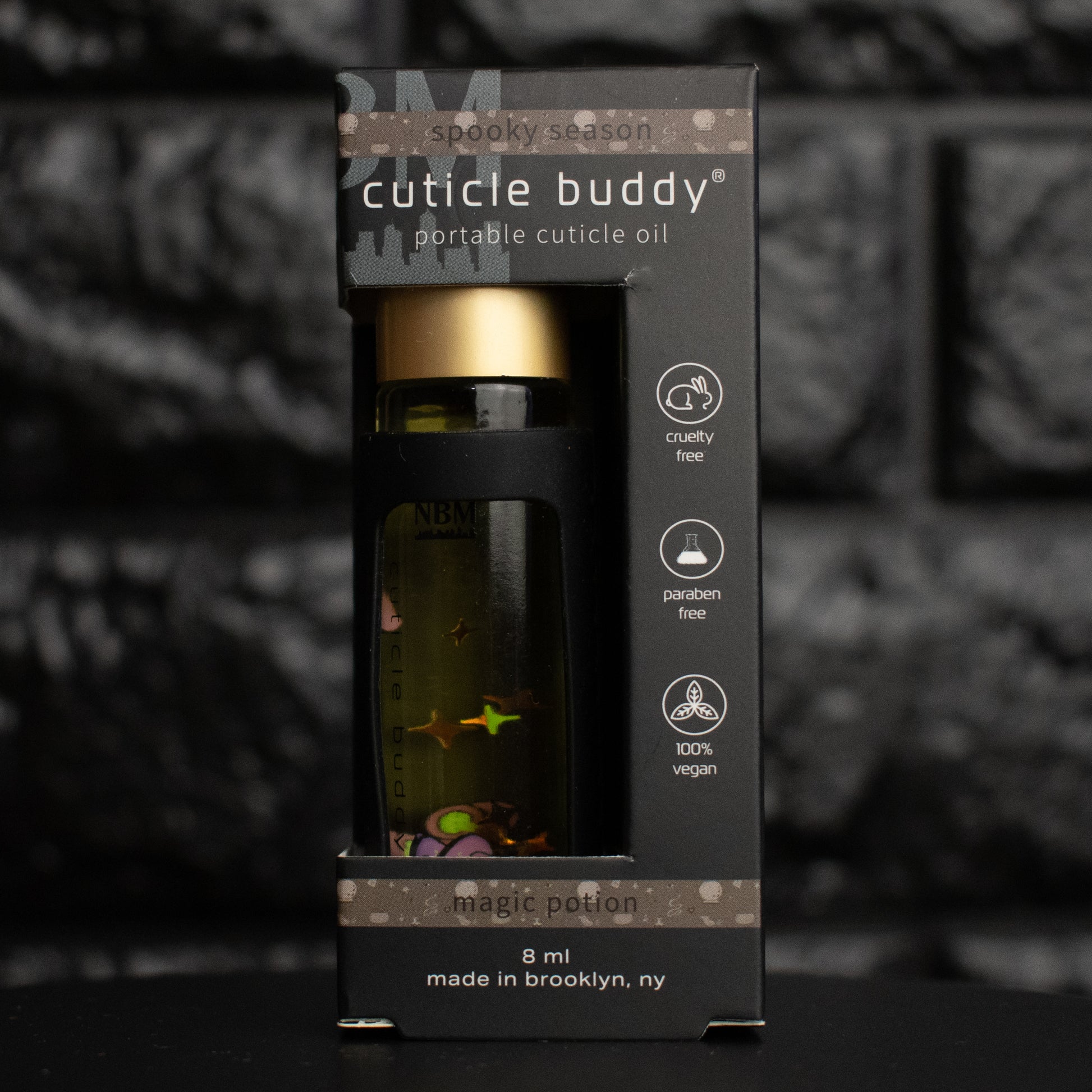 Cuticle buddy portable cuticle oil packaging with a dark background