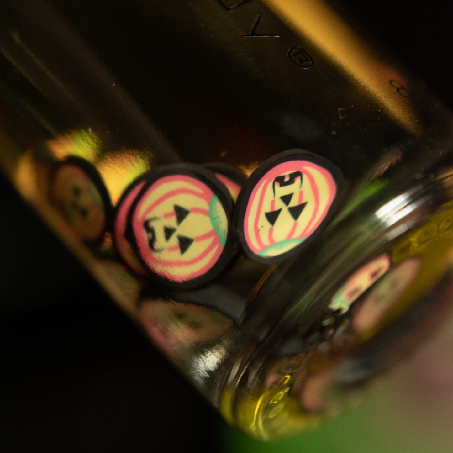 jack-o'-lantern fimo clay slices floating around inside a bottle of oil