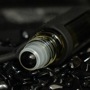 obsidian rollerball in a bed of obsidian stones