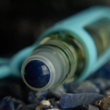 Load image into Gallery viewer, cuticle buddy™ soothing portable cuticle oil sodalite rollerball closeup in a pile of sodalite stones
