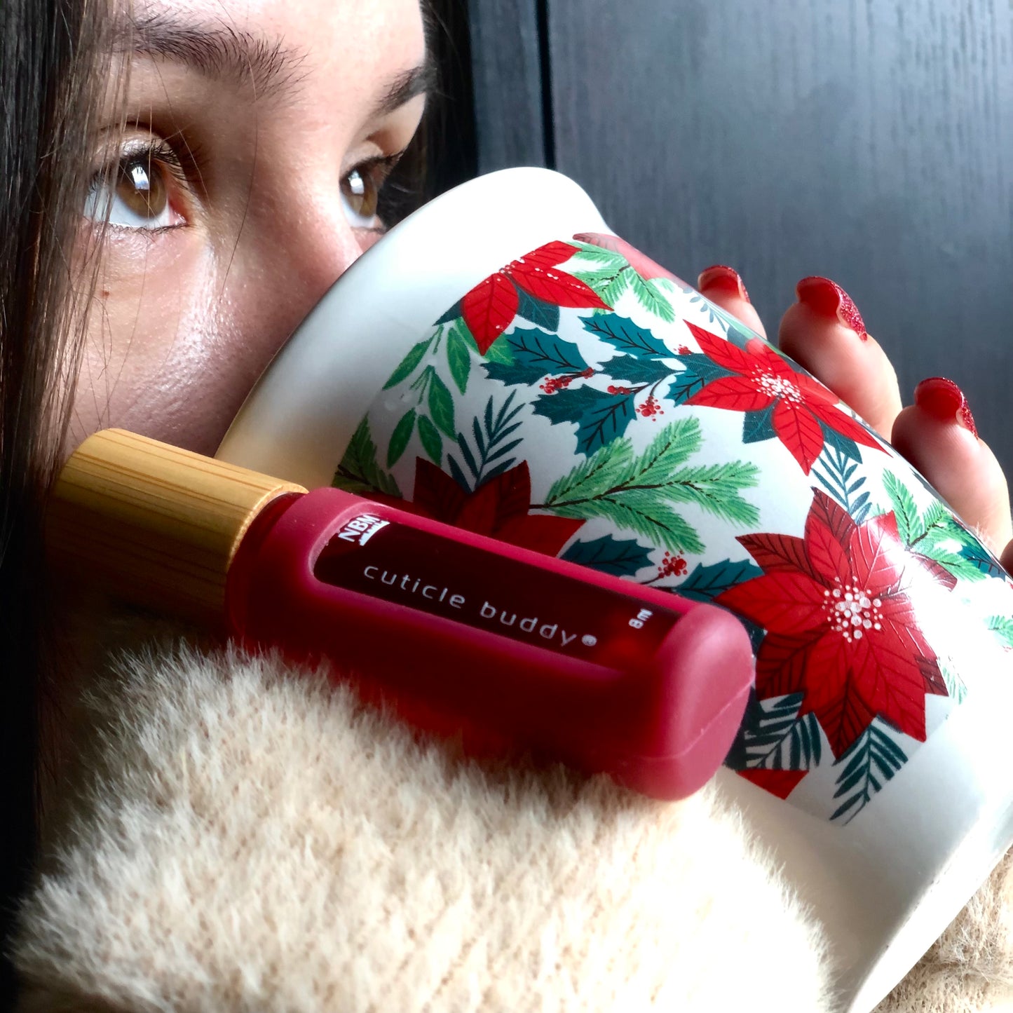 cuticle buddy hot chocolate hung off a mug as a girl sips from the mug