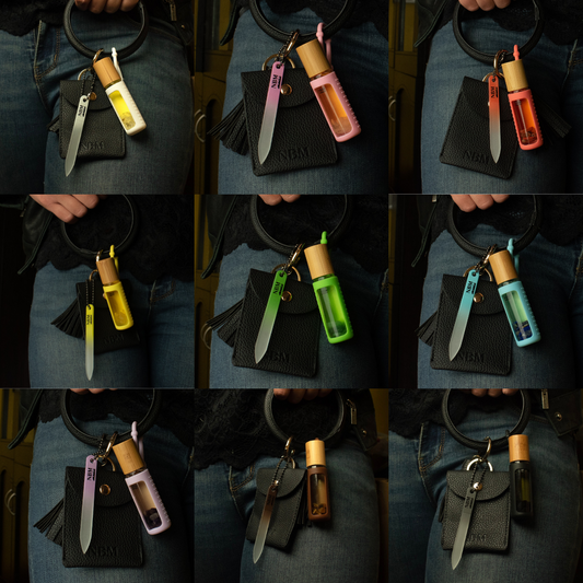 a collage of 9 different cuticle buddies hanging off a black leather bangle keychain wallet along with a matching glass nail file.